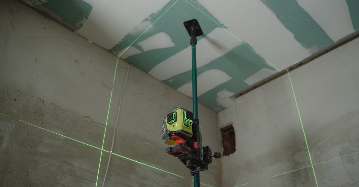 A laser level tool in action at an indoor construction site with marked walls.