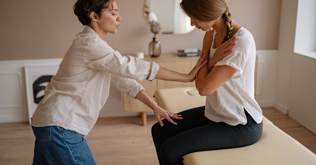 A therapist assisting a patient during a therapeutic session indoors, focusing on wellness and care.