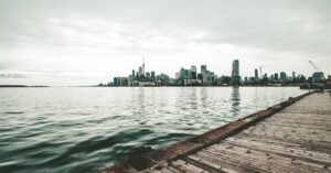 Dramatic view of Toronto skyline and CN Tower from Polson Pier on a cloudy day.